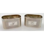 A pair of vintage serviette rings with engine turned decoration and engraved initials to front.