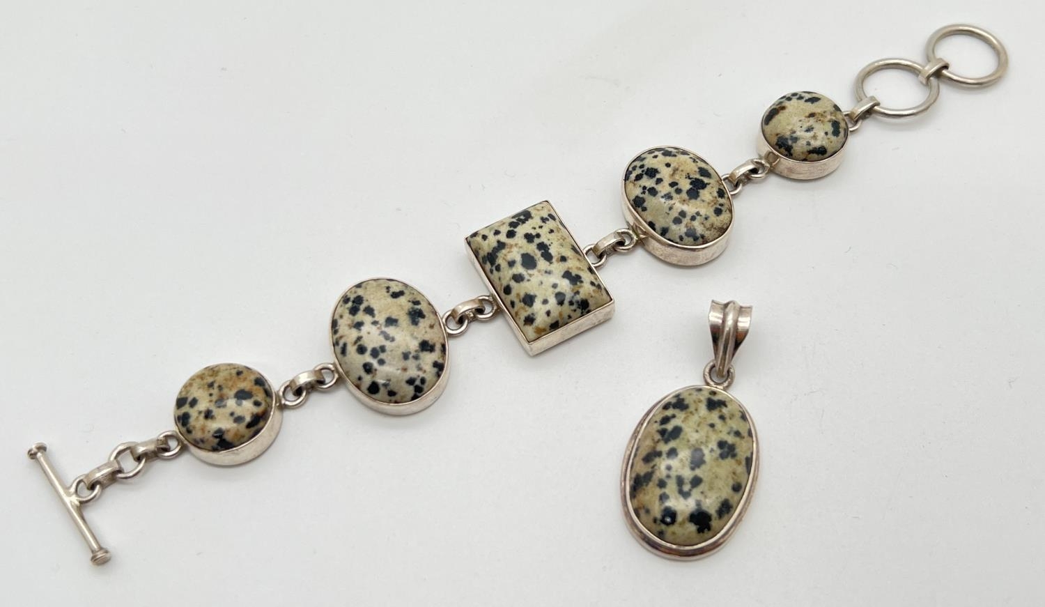 A modern design silver bracelet and matching pendant, set with Dalmatian jasper. Bracelet approx.