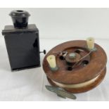 A large antique wooden fishing reel together with a vintage black metal paraffin lantern with red