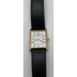 A men's square cased wristwatch by Seiko with black leather strap. White face with black hour