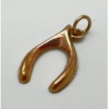 A 9ct gold wishbone charm/pendant. Full hallmarks to back. Approx. 0.4g. 2cm long including bale.