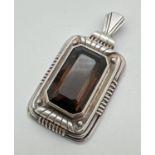 A large rectangular Art Deco style continental silver pendant set with an emerald cut smoked