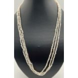 A 22 inch 3 strand small baroque pearl necklace with gold tone pierced work clasp.