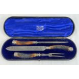 An Edwardian Mappin & Webb carving set with antler handles and white metal decorative collars and