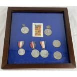 A framed and glazed collection of Royal coronation and commemorative medals and crowns. To include