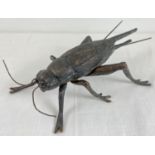 A modern heavy bronzed effect metal model of a cricket. Approx. 30cm long and weighs approx. 1.25Kg.