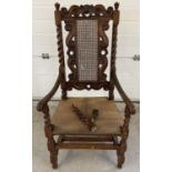 A late 17th century walnut high back armchair with barley twist columns. Carved scroll and cherub