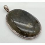A large oval cut labradorite cabochon pendant set in silver. Hallmarks to bale and silver mark to