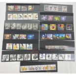 A collection of 13 sets of Royal Mail mint collectors stamps. To include: ITV, Trooping The