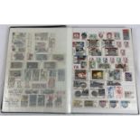A green vintage stamp album containing a collection of unused world stamps together with loose