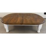 A low pine coffee table with varnish finish top and painted white base and legs. Approx. 31 x 105