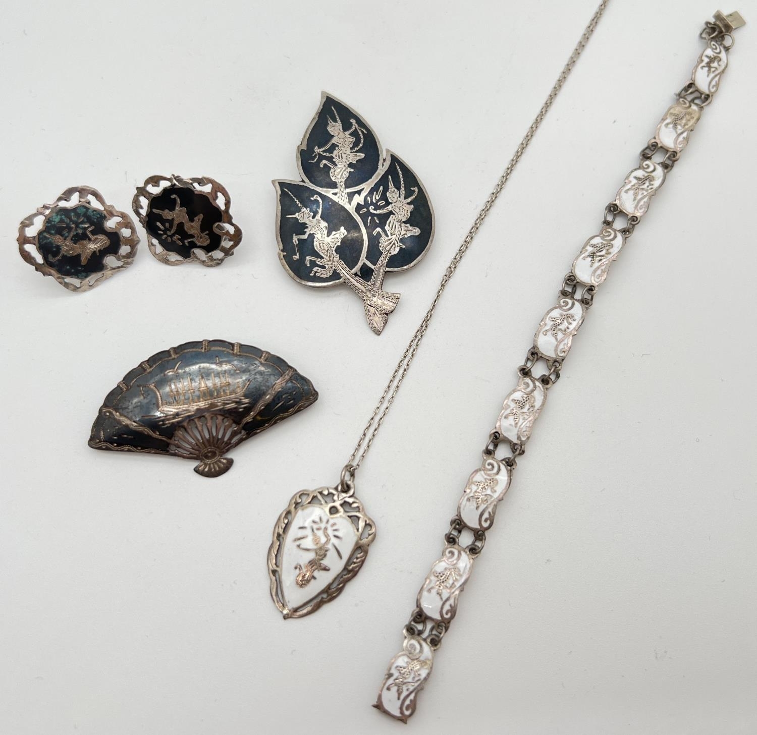 A collection of vintage Siam silver jewellery. A white enamelled pendant on an 18" fine belcher