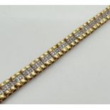 A silver gilt diamond set tennis style bracelet with push clasp. 31 panels set with 2 small round