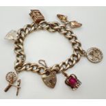 A vintage 1970's heavy silver curb chain charm bracelet with 6 charms. Heart shaped padlock clasp