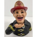 A painted cast iron mechanical money box modelled as a fireman. With lever action arm movement,