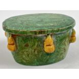 A small Chinese pottery stand with green and mustard majolica style glaze. Marbled effect green