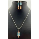 A modern design 18 inch silver pendant necklace with matching drop style earrings. All set with