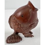 A small Japanese carved fruitwood pot in the form of an open mouthed fish. Set with small mother