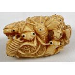 A carved bone netsuke in the form of a ring of crickets, beetles and bugs. Signature mark to