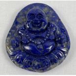 A carved lapis flat backed roundel featuring Buddha. Approx. 4.75cm x 4cm.