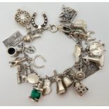 A vintage silver charm bracelet with 27 silver and white metal charms. Stamped silver on spring ring
