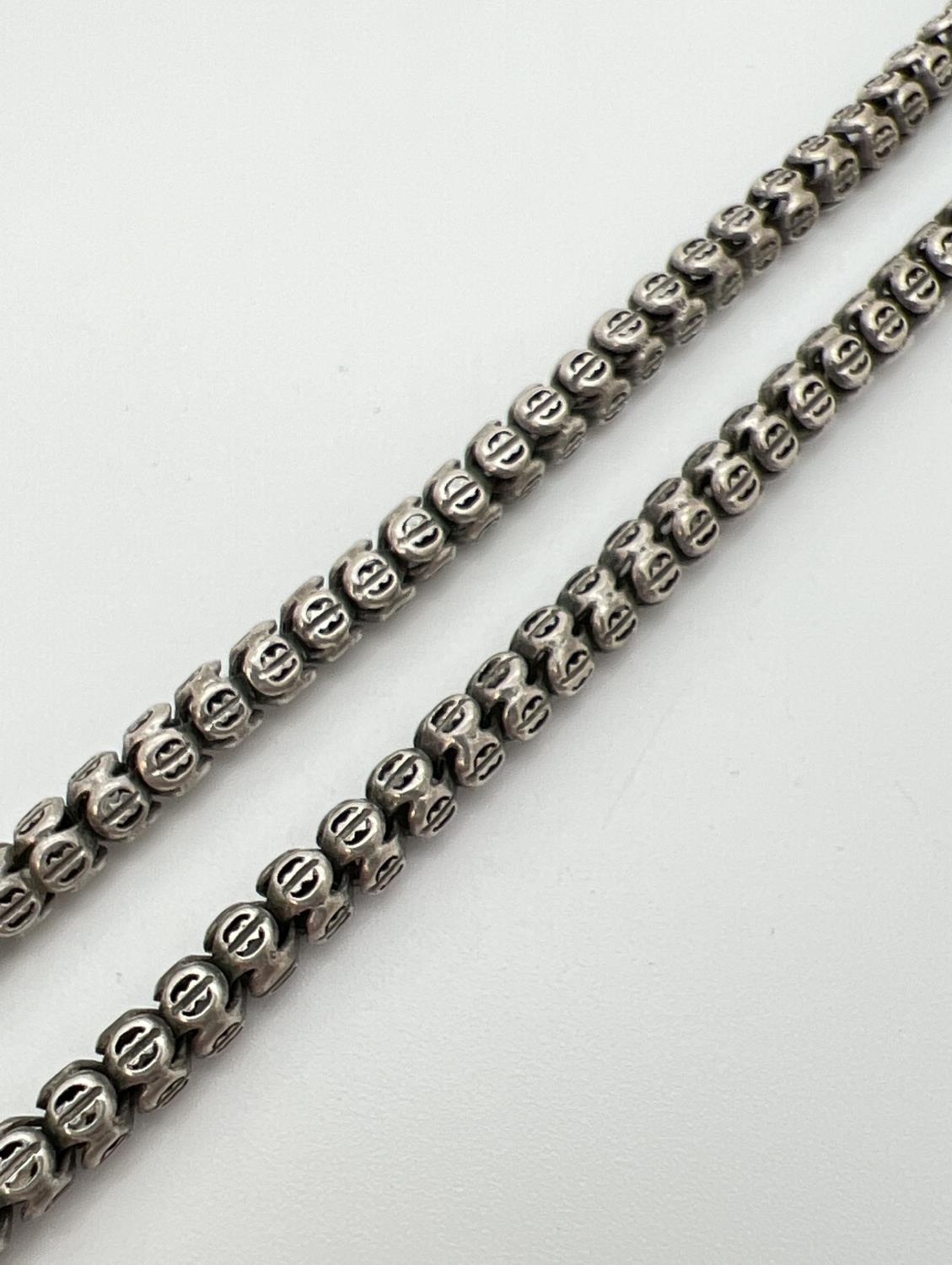 A 17 inch white metal bead chain necklace with pierced detail and barrel push clasp.