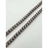 A 17 inch white metal bead chain necklace with pierced detail and barrel push clasp.