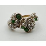 A vintage 9ct gold and silver bow design ring set with small cut emeralds and white faux pearls (two