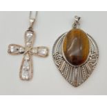 2 items of modern design silver jewellery. A cross shaped pendant set with teardrop shaped clear