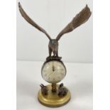An ornamental brass ball clock with eagle shaped finial and rabbit figures to base. With wind up