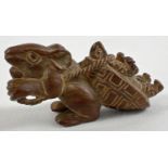 A carved wooden netsuke modelled as a mouse pulling a tortoise. Set with small mother of pearl