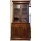 An Edwardian medium oak bookcase cabinet with floral carved design to cupboard doors. With