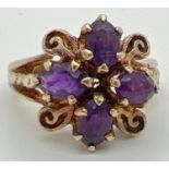 A vintage 9ct gold dress ring set with 4 oval cut amethysts in a floral design setting. Amethyst set