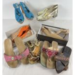 A collection of shoes and sandals in various styles and designs to include beaded flat sandals and