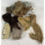 A collection of blonde and brunette hair pieces and wigs.