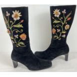 A pair of heeled ladies black faux suede calf length boots with floral embroidery and natural semi