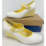 A boxed pair of canvas yellow and white Sarenza wedge heel Mary Jane shoes by Keds. With gingham