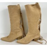 A pair of Cuban heeled pale tan soft suede pull on style cowboy boots with fringe wrap tassels by