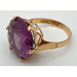 An 18k Egyptian gold dress ring set with a large round cut purple amethyst. Pierced heart detail