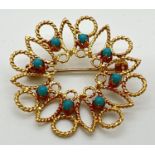 A 18ct gold open work circular brooch set with 8 small round turquoise cabochons. Secure pin to
