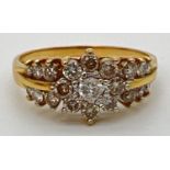 An 18ct gold .70ct diamond cluster style ring. Central round cut diamond surrounded by 8 small round