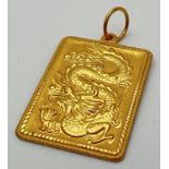 A 22ct gold large square pendant with oriental design dragon to front and geometric sun ray design