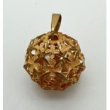 A 9ct gold ball shaped pendant with pierced floral design, on a fixed hanging bale. Full hallmarks