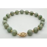 A green jade and 14ct gold bead bracelet with pierced work fishhook clasp. Alternating round green