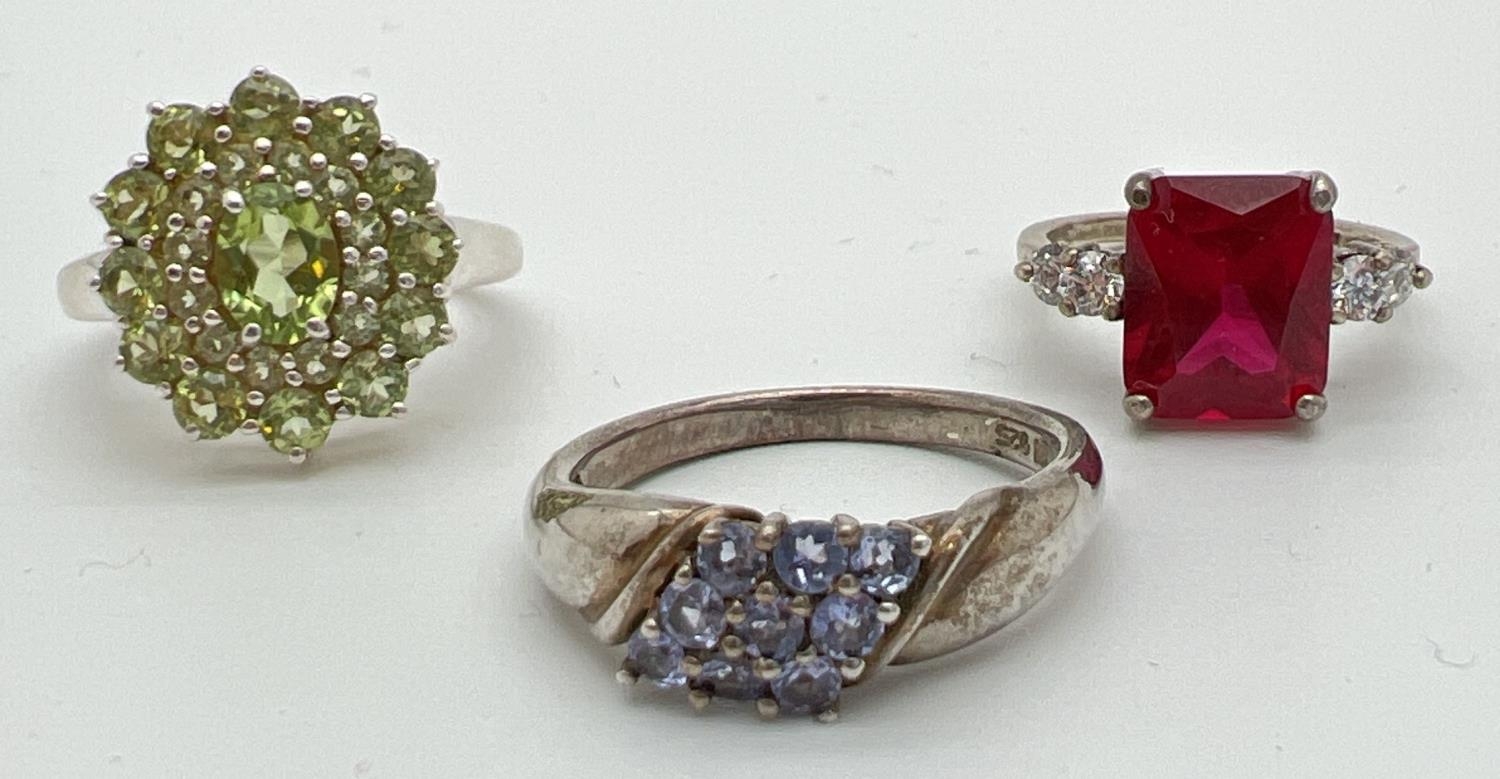 3 silver stone set dress/cocktail rings. A square cut red spinel with two round cut clear stones