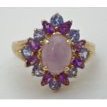 A 14K gold dress ring set with lavender jade, Iolite and amethyst stones. Central oval cabochon of