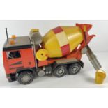 A 1:16 scale red, black and yellow hard plastic F16 Intercooler cement truck by Bruder. Moving parts