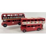 2 painted red modern tin plate double decker buses with Bus & Us decals to one side and Visit