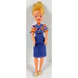 A vintage 1963 -65 Sindy doll with blonde hair. Dress in a later dated outfit of striped t shirt,