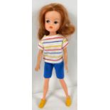 A vintage 1983 - 85 Sindy doll with auburn hair. In a vintage striped t shirt, blue shorts and
